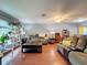 Living room with hardwood floors, comfortable seating, and a ceiling fan at 8015 Pequena Dr, Port Richey, FL 34668