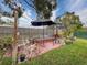 Relaxing backyard patio with seating area, umbrella, and string lights at 8015 Pequena Dr, Port Richey, FL 34668