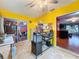 Sunroom with yellow walls, view into dining area, and workspace at 8015 Pequena Dr, Port Richey, FL 34668