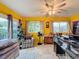 Sunroom with yellow walls, ceiling fan, and access to patio at 8015 Pequena Dr, Port Richey, FL 34668