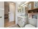 Cozy bathroom with updated cabinets, neutral walls, and mosaic tile flooring, viewed from hallway at 10200 Casey Dr, New Port Richey, FL 34654