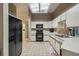 Functional kitchen featuring white cabinets, tile flooring, and black appliances at 10200 Casey Dr, New Port Richey, FL 34654