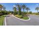 Landscaped entrance to a community with palm trees and brick pavers at 11061 Egeria Dr, Odessa, FL 33556