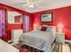 Cozy bedroom with red walls, featuring a comfortable bed and dresser at 12529 Shadow Ridge Blvd, Hudson, FL 34669