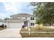 Two-story house with gray siding, a two-car garage, and landscaping at 1302 Dragon Head Dr, Valrico, FL 33594