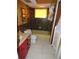Retro bathroom with dark brown tiled walls, a yellow tub, and red vanity at 13618 Stacey Dr, Hudson, FL 34667