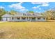 Front view of a two-story house with gray siding, a large front porch, and a spacious lawn at 14325 Highgrove Rd, Brooksville, FL 34609