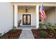 Double front doors and a covered porch with a flag at 18025 Nimick Rd, Weeki Wachee, FL 34614