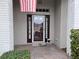 Front entry with glass door, brick columns, and welcome mat at 18049 Tarrington Pl, Hudson, FL 34667