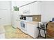 White kitchen with tile backsplash and appliances at 18049 Tarrington Pl, Hudson, FL 34667