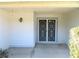 White front door with decorative iron screen and small covered porch at 2185 Carriage Ln, Spring Hill, FL 34606