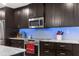 Modern kitchen with stainless steel appliances and blue backsplash at 23051 Lake Lindsey Rd, Brooksville, FL 34601