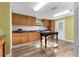 Bright kitchen featuring wood cabinets, tile backsplash, and vinyl flooring at 23051 Lake Lindsey Rd, Brooksville, FL 34601