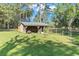 Gray storage shed with metal roof in sunny backyard at 23051 Lake Lindsey Rd, Brooksville, FL 34601