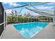 Large screened pool with surrounding lush greenery at 2643 Narcissus Dr, Holiday, FL 34691