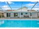 Inviting swimming pool with covered patio and seating area at 2643 Narcissus Dr, Holiday, FL 34691
