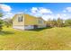 Yellow single-story house with a large backyard and covered deck at 39705 Sunburst Dr, Dade City, FL 33525