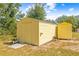 Two yellow storage sheds with a ramp and tire at 39705 Sunburst Dr, Dade City, FL 33525