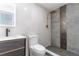 Modern bathroom with grey tile, gold fixtures, and floating vanity at 405 Pine S Ave, Oldsmar, FL 34677