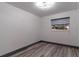 Simple bedroom with wood-look floors and a window with blinds at 405 Pine S Ave, Oldsmar, FL 34677