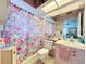 Pink bathroom with floral shower curtain, toilet, and vanity at 4912 Enfield Ct, New Port Richey, FL 34655