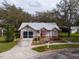 Single story house with grey roof, red accents, and a screened garage at 4912 Enfield Ct, New Port Richey, FL 34655