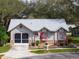 Cute single-story house with a gray roof, red accents, and a screened garage at 4912 Enfield Ct, New Port Richey, FL 34655