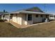 Tan single story house with gray roof and landscaping at 705 Churchill Pl, Sun City Center, FL 33573
