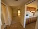 View of kitchen and living area with wooden cabinetry and carpeted floor at 705 Churchill Pl, Sun City Center, FL 33573