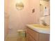 Small bathroom with a single sink vanity, toilet, and a round mirror at 7714 Jasmine Blvd, Port Richey, FL 34668