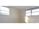 Simple bedroom with neutral walls, two windows, and ample natural light at 7714 Jasmine Blvd, Port Richey, FL 34668