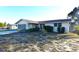 Ranch home with a flat roof, light-colored exterior, and a small front yard at 7714 Jasmine Blvd, Port Richey, FL 34668