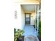Front entrance with a glass door, light blue floor, and decorative column at 7714 Jasmine Blvd, Port Richey, FL 34668