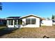 Back of house, showcasing sunroom and yard at 7714 Jasmine Blvd, Port Richey, FL 34668