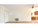Empty living room with tile floors, a white door, and kitchen view at 7714 Jasmine Blvd, Port Richey, FL 34668