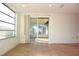 Living area with sliding glass doors leading to a sunroom and tile floors at 7714 Jasmine Blvd, Port Richey, FL 34668