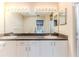 Double vanity bathroom with granite countertop and large mirror at 8111 Sugarbush Dr, Spring Hill, FL 34606