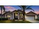 Two-story house with a double door entry and a three-car garage at 9105 Flagstick Ln, Hudson, FL 34667