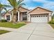 Two-story house with columns, a palm tree, and a three-car garage at 9105 Flagstick Ln, Hudson, FL 34667