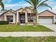 Two-story house with columns, palm tree, and a three-car garage at 9105 Flagstick Ln, Hudson, FL 34667