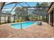 Relaxing screened pool and spa with pavers and lounge chairs at 9105 Flagstick Ln, Hudson, FL 34667