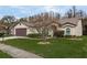 Landscaped yard with a one-story house and brown garage door at 9639 Conservation Dr, New Port Richey, FL 34655