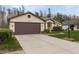Front view of a one-story house with a large driveway and brown garage door at 9639 Conservation Dr, New Port Richey, FL 34655