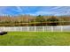 Green grassy backyard with lake view and white fence at 11777 Crestridge Loop, New Port Richey, FL 34655