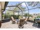 Relaxing screened patio with seating area and grill, overlooking a lake at 12219 Arron Ter, Trinity, FL 34655