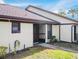 Exterior view of a condo with a brown door and light-colored walls at 1355 Powderpuff Dr # 908, Dunedin, FL 34698