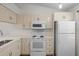 White kitchen appliances and cream cabinets, ample counter space at 1355 Powderpuff Dr # 908, Dunedin, FL 34698