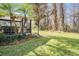 Landscaped backyard with grassy area and screened patio at 1413 Morning Rose Pl, Trinity, FL 34655