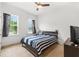 Cozy bedroom with a striped comforter and ample natural light at 14455 Chimney Swift Rd, Weeki Wachee, FL 34614