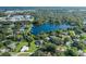 Aerial view showcasing a house's location near a lake and other homes at 1523 Fishing Lake Dr, Odessa, FL 33556